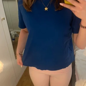 Blå t-shirt från Massimo Dutti - Säljer en stilren blå t-shirt från Massimo Dutti. Den har en klassisk rund hals och korta ärmar, perfekt för en avslappnad look. Tillverkad i ett mjukt och bekvämt material.