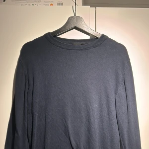 Mörkblå tröja från LMTD - Säljer en stilren mörkblå tröja från LMTD. Tröjan har långa ärmar och ribbade muddar vid ärmslut och nederkant. Perfekt för en avslappnad look, stickad tröja som passar perfekt till en chill dag 