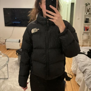 Svart pufferjacka från The North Face - Säljer en snygg och varm svart pufferjacka från The North Face. Perfekt för kalla dagar med sin tjocka vaddering och långa ärmar. Jackan har en dragkedja framtill och är i bra skick. Passar perfekt för både höst och vinter. Storleken är dam S. Använt ett antal gånger.