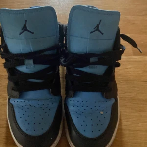 Nike Air Jordans i blått och svart - Säljer ett par Nike Air Jordans i blått och svart. Skorna har snörning och är i bra skick med lite slitage på sulorna. Perfekta för både vardag och fest! 🏀 KAN RENGÖRA SKORNA OM NÅN KÖPER!  SKRIV TILL MIG HUR MYCKET NI VILL HA DOM FÖR!