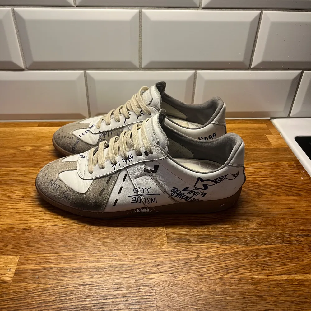 Säljer ett par unika limited edition Maison Margiela i vitt och grått som inte säljs längre. KAN GÅ NER I PRIS. De har även en skada på höger av skon, fråga om ni vill ha bilder på skadan. Skor.