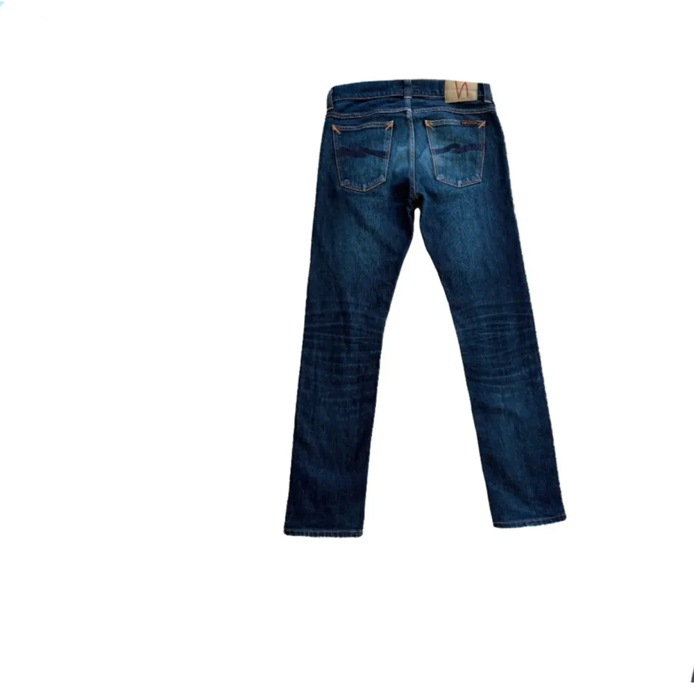 Säljer ett par snygga blå jeans från Nudie modell ”Tilted tor” i nyskick. De har en klassisk femficksdesign och är tillverkade i slitstarkt denim. Perfekta för både vardag och fest! Passformen är slimfit och de har en normal midja. Kontakta mig för mer info eller fler bilder!. Jeans & Byxor.