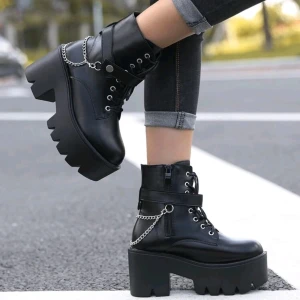 Svarta chunky boots med kedjedetalj - Säljer ett par svarta chunky boots i skinn med coola kedjedetaljer och snörning. De har en rejäl klack och dragkedja på sidan för enkel på- och avtagning. Perfekta för höst och vinter när du vill ha en edgy look. Passar både till jeans och klänning!