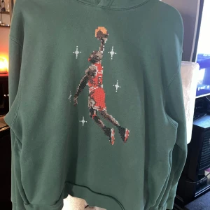 Jordan tröja Grön hoodie - Säljer en grön hoodie med ett coolt basketmotiv. Perfekt för sportiga dagar eller bara för att chilla. Den har en avslappnad passform och är superbekväm. Passar perfekt till jeans eller träningsbyxor. Hör av dig om du är intresserad! 🏀