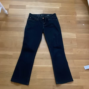 Mörkblå jeans med bootcut - Säljer ett par snygga mörkblå jeans från Levi's i bootcut-stil. De har en klassisk femficksdesign och en läderpatch baktill. Perfekta för både vardag och fest!💗💗