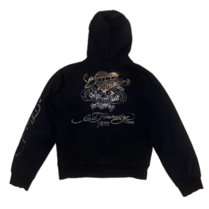 Ed Hardy zip up - Så snygg zip up hoodie från Ed Hardy! Tyget är lite tjockare och den håller värme bra, perfekt nu när det blir kallare. Några stenar har lossnat. Den är lite kortare i modellen, mer åt det croppade hållet. Skriv för fler bilder eller om du har frågor💫