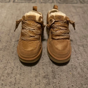 UGG Lowmel 'Chestnut' - Helt nya och oanvända UGG Lowmel i chestnutfärg. Dessa vinterskor kombinerar komfort och värme med en vattentålig yta och halkfri sula. Perfekta för både vardag och kalla vinterdagar.