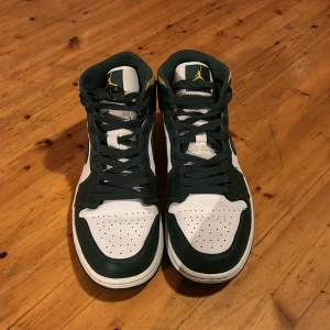Nike Air Jordans i grönt och vitt - Säljer ett par snygga Nike Air Jordans i grönt och vitt med gula detaljer. Skorna har klassisk snörning och är i mycket bra skick. Perfekta för både vardag och fest! 🏀