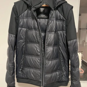 Hugo boss hybrid vinter jacka - Säljer en snygg svart pufferjacka från Hugo Boss👑. Jackan har avtagbara ärmar, vilket gör den perfekt för både höst,vår och nästan alla årstider. Jackan är en hybrid jacka. Perfekt jacka och väst 💫jackan är typ helt ny med inget smuts eller defekter🍾 skriv om frågor💯