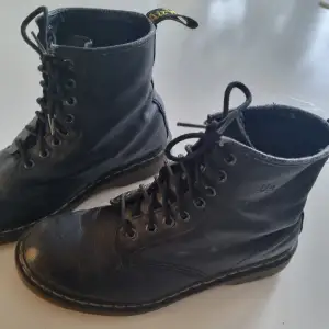 Säljer ett par klassiska Dr. Martens kängor med snörning i storlek 40. De är köpta second hand för ett par år sen och har lite slitage på tån och högst upp vid fotleden. Slitaget syns även inne i skon där storleken inte längre är synlig. Innersulan är 26cm