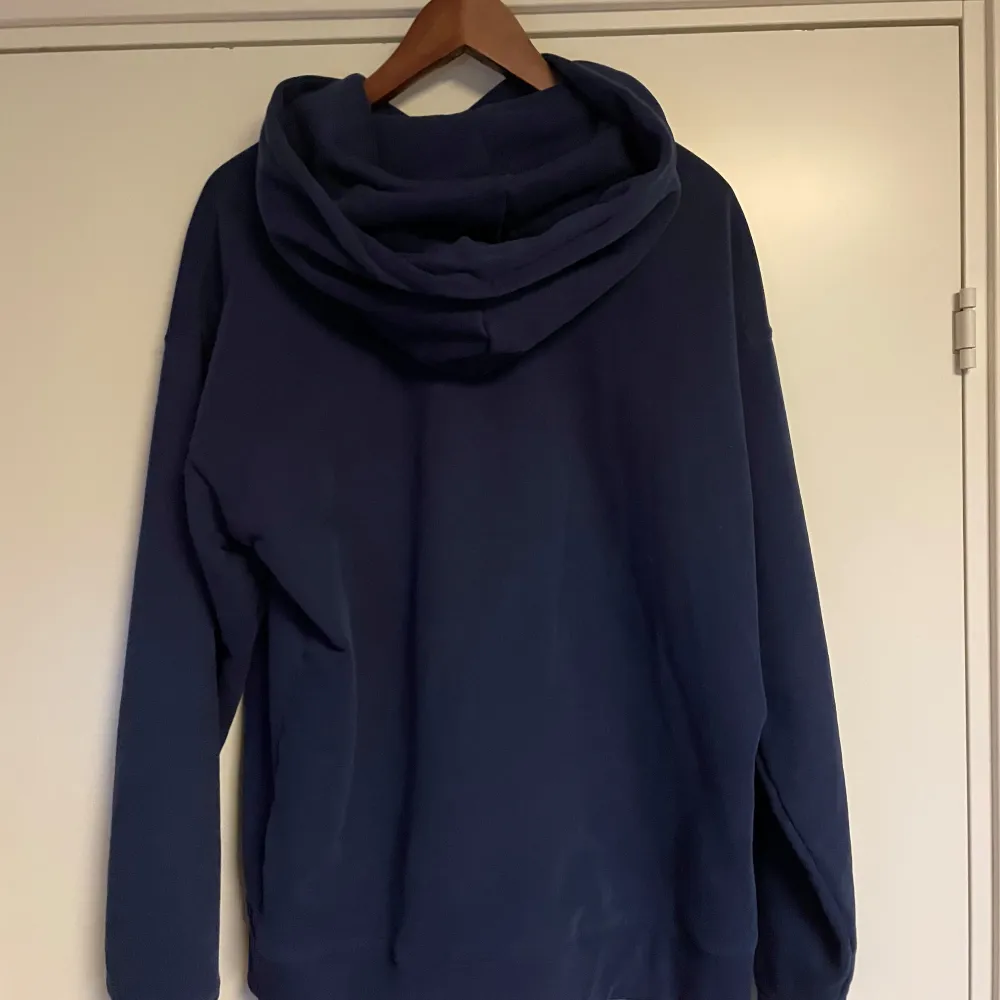 Säljer en snygg och bekväm mörkblå hoodie från Levi's. Den har en klassisk design med en liten logga på bröstet och en stor ficka framtill. Perfekt för kyliga dagar eller mysiga hemmakvällar. Passar till det mesta i garderoben!. Tröjor & Koftor.