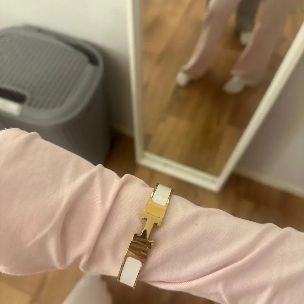 Snyggt armband i vitt och guld med en elegant design. Perfekt för att ge en touch av lyx till vilken outfit som helst. Armbandet har en stilren och modern look, idealisk för både vardag och fest.. Accessoarer.