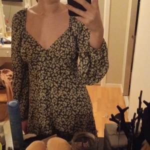 Blommig klänning med långa ärmar - Säljer en supersöt blommig klänning med långa ärmar och v-ringning. Perfekt för både vår och sommar! Den har en fin passform och är riktigt bekväm att ha på sig. Klänningen är i mycket bra skick och passar perfekt till både vardag och fest.