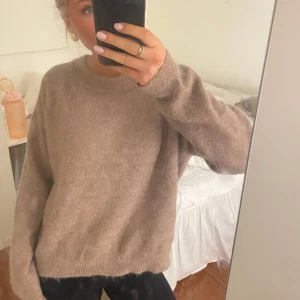 Beige stickad tröja från Zara - Mysig beige stickad tröja från Zara i alpacka. Perfekt för höst och vinter med sin varma och bekväma passform. Tröjan har långa ärmar och en klassisk rund halsringning. Den är i mycket bra skick och passar perfekt för en avslappnad stil. 
