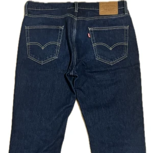 Mörkblå Levi’s jeansbyxor - Säljer ett par klassiska levis mörkblå jeansbyxor som är knappt använda. De har en straight passform i storlek 33/30. Priset kan diskuteras vid snabb affär!