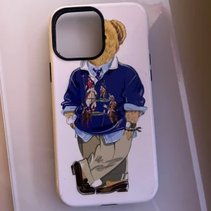 Mobilskal med björnmotiv - Snyggt mobilskal med en cool björn i preppy outfit. Skalet är vitt med en illustration av en björn i blå tröja och beige byxor. Perfekt för att ge din mobil en unik stil och skydd.