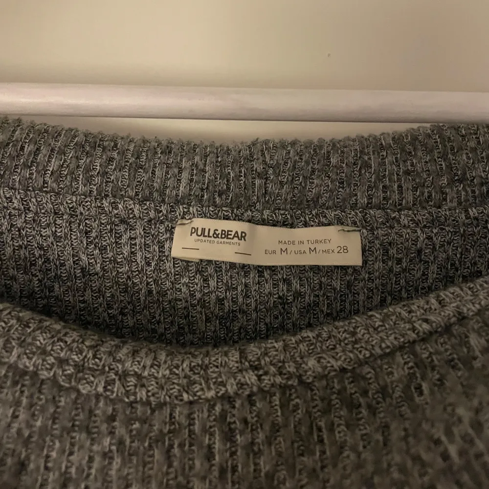 Säljer en snygg grå offshoulder tröja från Pull&Bear. Den är stickad och har långa ärmar, perfekt för höst och vinter. Tröjan är i bra skick och passar både till vardags och fest. Superbekväm och stilren!. Tröjor & Koftor.