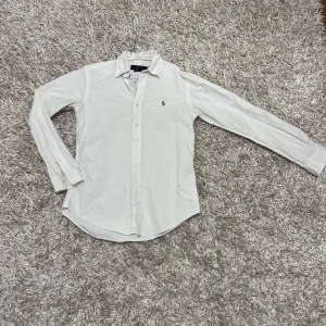  Ralph Lauren skjorta - Säljer en klassisk vit skjorta från Ralph Lauren i storlek S. Skjortan har en broderad logga på bröstet och är i mycket bra skick. Perfekt för både vardag och fest! 👔Kontakta mig privat för för fler frågor!