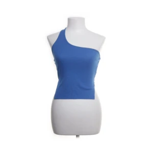Blå oneshoulder topp - Snygg blå oneshoulder topp i ribbat material. Toppen har en tight passform som framhäver figuren. 