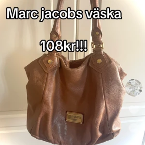 Brun väska från Marc Jacobs - Säljer en snygg brun axelväska från Marc Jacobs i skinn. Väskan har en stilren design med guldfärgade detaljer och en praktisk innerficka med dragkedja. Perfekt för både vardag och fest! 👜✨ska tvätta den! den är välanvänd men inget man ser jättetydligt❤️