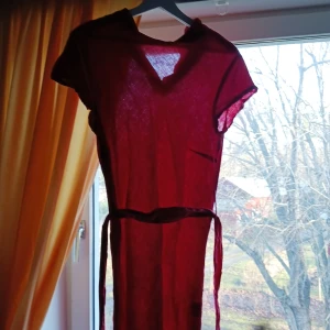 Röd klänning från Milook - Säljer en röd klänning från Milook i storlek S. Den har en enkel design med korta ärmar och ett knytband i midjan. Perfekt för sommardagar eller en avslappnad vårutflykt. Materialet är lätt och luftigt, vilket gör den bekväm att bära. Passar både till vardags och festligare tillfällen.