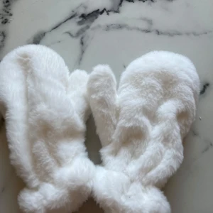 Vita fluffiga vantar - Supermysiga vita vantar i fluffigt material, perfekta för kalla vinterdagar. De är riktigt varma och sköna, med en mjuk insida som håller händerna varma. Vet tyvär inte märket!