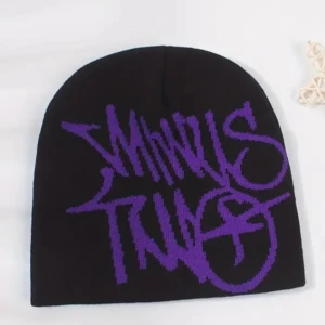 Jacquard beanie svart o lila - Cool svart mössa med stor lila text i graffiti-stil. Perfekt för att hålla sig varm och stilren under kyliga dagar. Passar både till vardags och för att ge en edgy touch till din outfit.