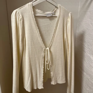 Vit kofta från Vila - Fin ribbstickad äggvit kofta från Vila. Något nopprig (sista bilden) men inget som inte går att ordna med en noppermaskin. Säljer då jag inte använder den💕