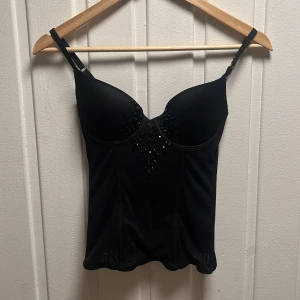 Svart korsett från H&M - Snygg svart korsett med push up från HM! Korsetten har fina detaljer och inga defekter. Storlek 75B och skulle säga passar de som har storlek xs/s. 