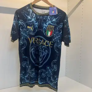 Säljer en snygg blå fotbollströja från Italien och Puma med ett detaljerat mönster i ljusblått och guld. Tröjan har korta ärmar och ett elegant mönster med italienska landslagets emblem. Perfekt för fotbollsfans som vill sticka ut! Storlek s priset kan diskuteras 