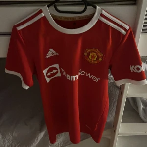 Manchester United tröja - En Manchester United tröja i storlek Xs. Väldigt fint skick den ända defekten är ett litet hål i sömmen på sidan av tröjan annars felfri. Pris kan diskuteras vid snabb affär 