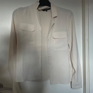Crème Färgad Skjorta  - sparsamt använd men har en liten fläck på vänster sida.