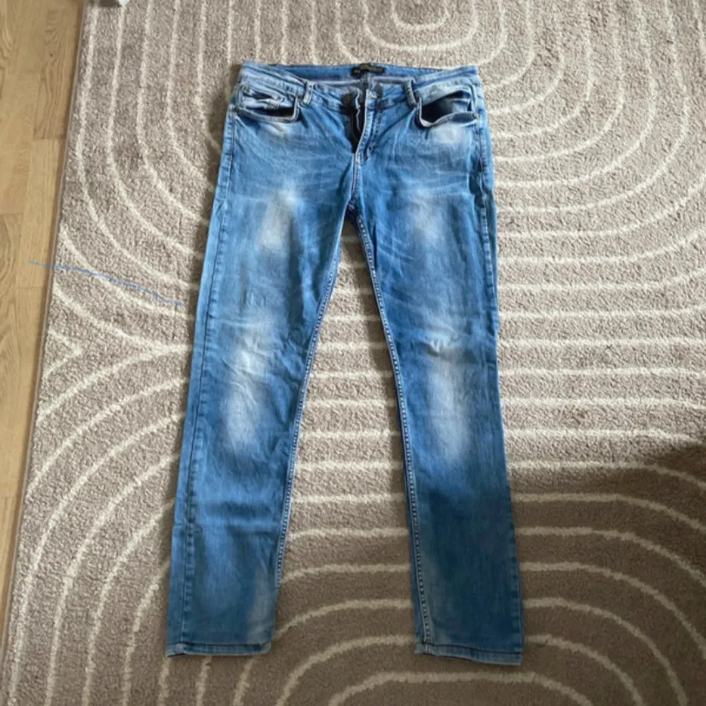 Säljer ett par snygga blå jeans från Dsquared2. De har en klassisk femficksdesign och en cool, sliten look. Perfekta för både vardag och fest! 🕺. Farkut & Housut.