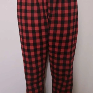 Röd och svart rutiga byxor - Säljer ett par supercoola röd- och svartrutiga byxor. Perfekta för höst och vinter med sitt mysiga mönster. De har en normal passform och är gjorda i ett bekvämt material. Perfekta för en avslappnad stil eller en chill dag hemma.