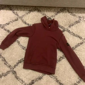 Stone island hoodie  - Jag säljer en stone island hoodie i färg vinröd. Varan är i storlek 12 år/156. Hoodien har tecken på användning men är i väldigt bra skick.