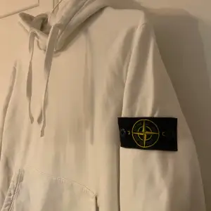 Säljer en snygg vit hoodie från Stone Island. Nypris är mins 4000. Den har en klassisk design med en stor ficka fram. På ärmen finns det snygga Stone island märket. Den har små fläckar på framsidan men inget man direkt tänker på. Kom med prisförslag 