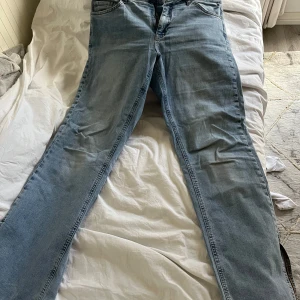 Ljusblå bootcut jeans - Snygga ljusblå jeans med klassisk femficksdesign och dragkedja. Perfekta för en avslappnad stil. De har en rak passform och är tillverkade i ett slitstarkt denimtyg. Köpte dem för 300kr. Använt mycket men ingen fläck och är inte sönder någon stans.