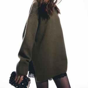 Olivgrön stickad polotröja - Säljer en olivgrön stickad polotröja med långa ärmar och ribbade muddar. Tröjan har en lös passform och är perfekt för kyligare dagar. Den har en stilren design som passar till många olika outfits.