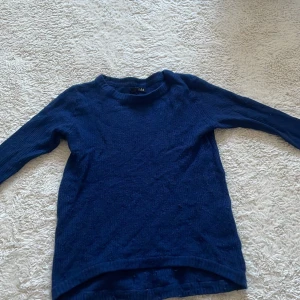 Mörkblå tröja från Anna Catherine - Säljer en stilren mörkblå tröja från Anna Catherine. Tröjan är väl använd och därför lite nopprig. (Obs jag skulle söga att storleken är runt  146-152)