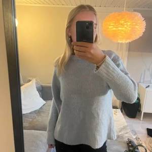 Ljusblå stickad tröja - Säljer en mysig ljusblå stickad tröja med långa ärmar. Perfekt för kyligare dagar och har en avslappnad passform. 