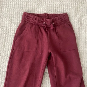 Vinröda mjukisbyxor med snörning - Säljer ett par vinröda mjukisbyxor med elastisk midja och snörning. Byxorna har två framfickor och två bakfickor,tror att dom är från lager 157(lappen är avdragen)