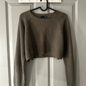 Grå/brun stickad croppad tröja - Säljer en snygg beige stickad tröja från shein. Den är croppad med långa ärmar och har en ribbad design. Hör av dig vid intresse❣️