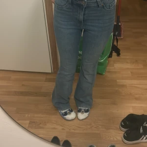 Blå jeans med bootcut - Snygga blå jeans med bootcut-stil och hög midja. Perfekta för en avslappnad look. Klassisk design med fem fickor och knappgylf.