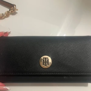 tommy hilfiger väska - Säljer min fina plånbok då den inte används längre, fin till vardagen men även uppklätt!
