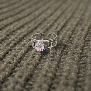 Sunflower Bliss - Silver Ring with Stone - US storlek 7, diameter 17,3 mm, omkrets 54,4 mm. En strålande ring med ett vackert solrosmotiv som omger en gnistrande sten. Den justerbara designen gör den perfekt för både vardag och fest.