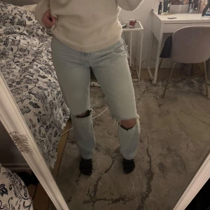 Ljusa jeans med slitningar - Ett par ljusblå Jeans från Gina tricot i storlek 38. De är högmidjade med hål i knäna. De är i bra skick då de endast använts ett få tal gånger. Pris går att diskutera!