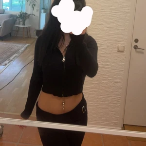 Svart croppad hoodie med dragkedja - Säljer en svart croppad hoodie med dragkedja framtill och byxorna till. De är supermjuka och bekväma. Hoodien har långa ärmar och en tight passform. har endast används 1 gång, helt nytt skick. priset kan diskuteras ❤️säljer både byxorna och koftan tillsammans (kan sälja en och en också)