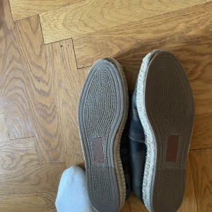 Camouflagefärgade espadrillos - Säljer ett par snygga och bekväma espadrillos med camouflage-mönster. Skorna har en klassisk espadrillos-design med en flätad sula och är perfekta för sommaren. De är i bra skick och passar perfekt för en avslappnad stil.