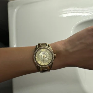 Fossil Klocka i Nyskick - Guldig klocka från Fossil med silver detaljer, klockan är använd ca 2-3 gånger så är i stort sett ny. Säljer eftersom jag har en annan klocka jag använder mer. Ligger ute på fler ställen.