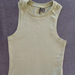 Grönt ribbat linne - Säljer en snygg grön ribbad linnetopp från Vero Moda. Materialet är mjukt och stretchigt, vilket gör den bekväm att bära hela dagen. Inga defekter, skriv vid frågor💚💚🥰